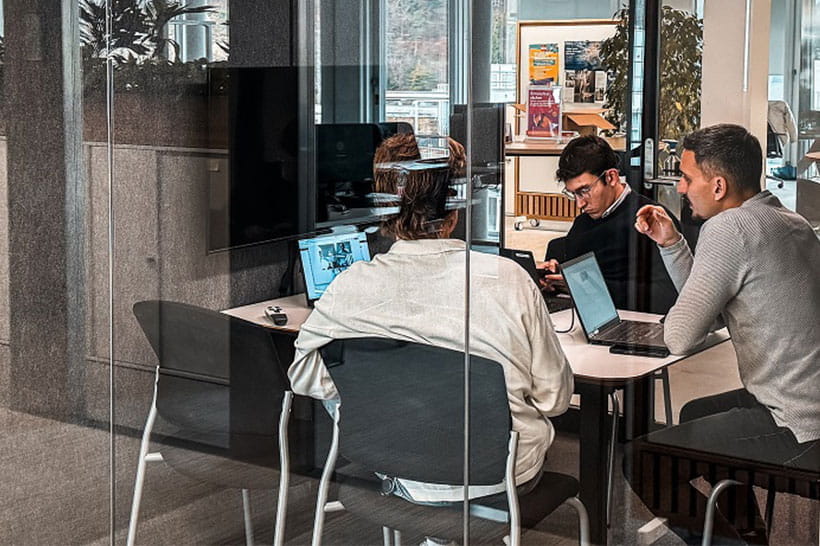 Drei Projektleiter von Migrol Charge besprechen sich in einer Sitzungsbox.